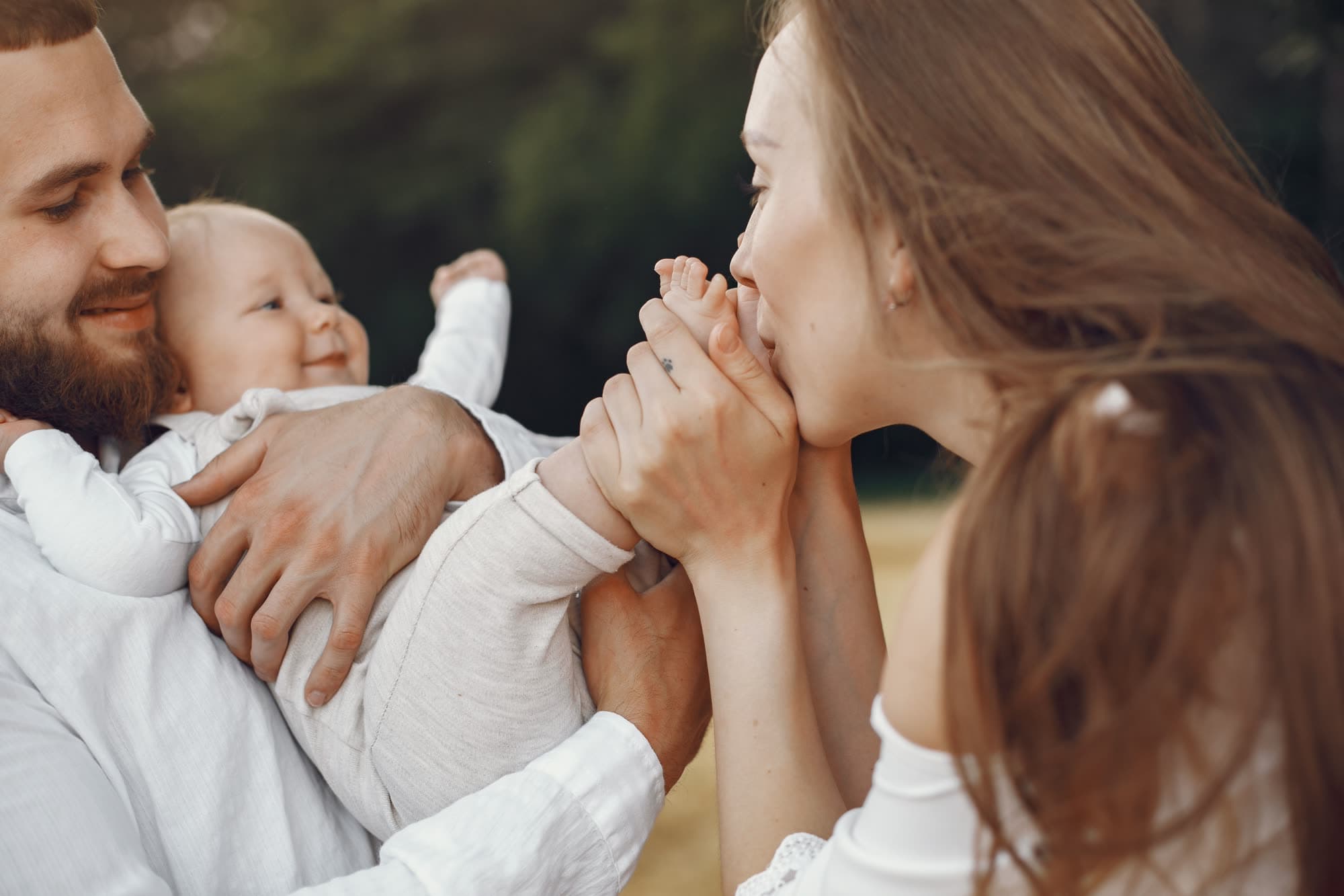 Parents tenderly holding their baby's hands